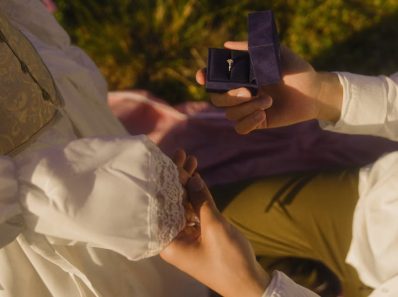 Vintage-inspired outdoor proposal with engagement ring and romantic atmosphere.